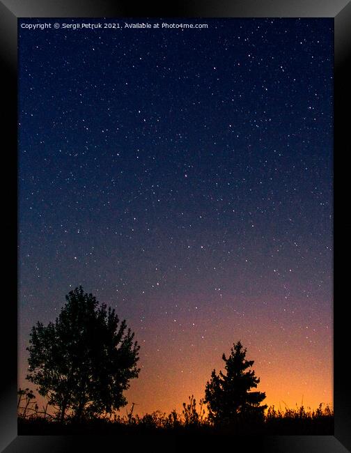 Silhouettes of low trees against the background of the night starry sky and the setting sun. Framed Print by Sergii Petruk