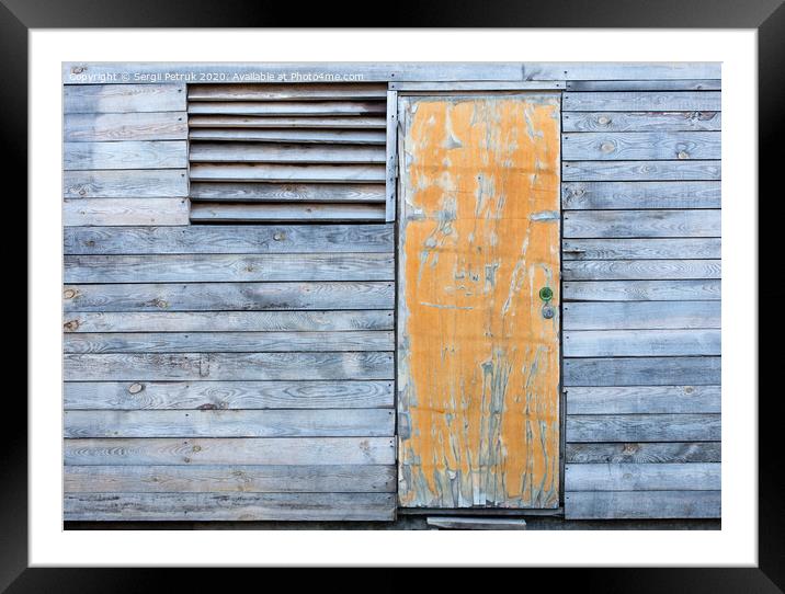 Wooden old weather-beaten barn with a yellow old door Framed Mounted Print by Sergii Petruk