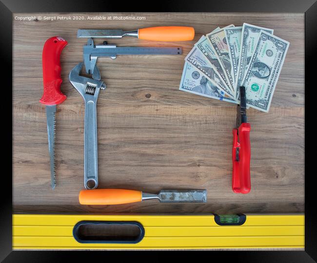 Old construction tools and a set of dollar bills on a wooden table close-up Framed Print by Sergii Petruk