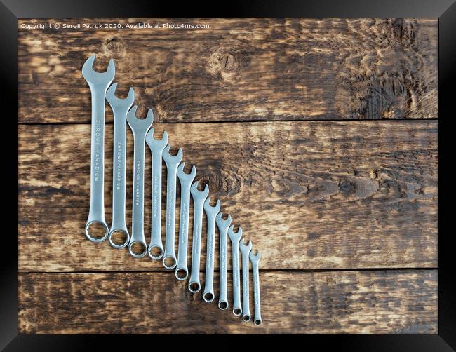 set of wrench against old wooden boards background Framed Print by Sergii Petruk