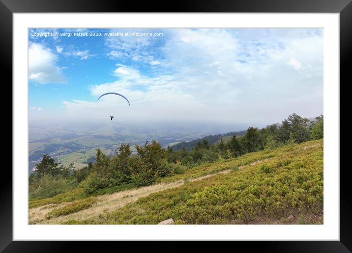 A flying paraglider against the blue sky, in the morning fog of the Carpathian Mountains Framed Mounted Print by Sergii Petruk