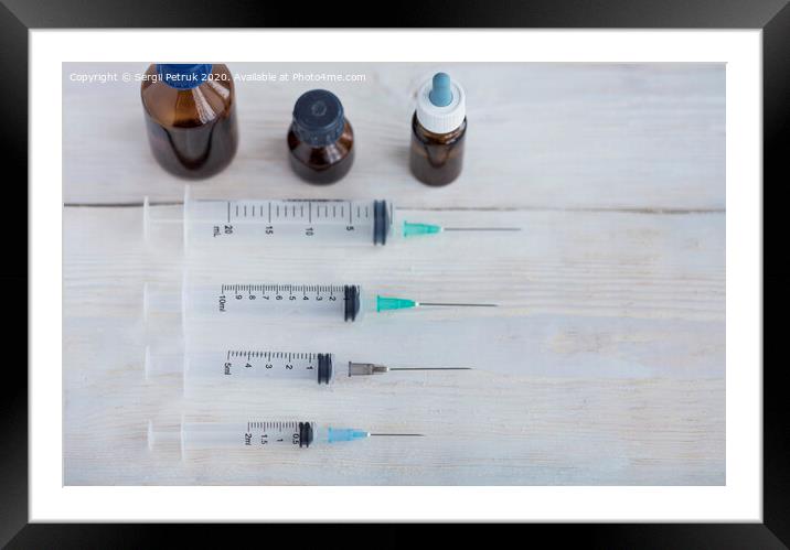 Syringes and capsules, medical ampoules on a white wooden table. Framed Mounted Print by Sergii Petruk