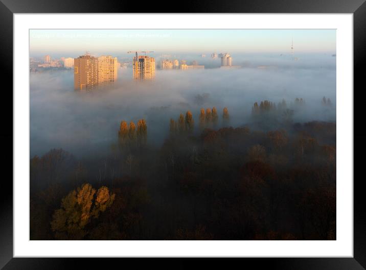 The sun's rays illuminate the morning city through the dense autumn fog Framed Mounted Print by Sergii Petruk