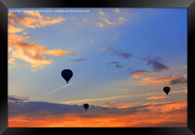 Silhouettes of balloons on the background of the morning sky with fiery red clouds. Framed Print by Sergii Petruk