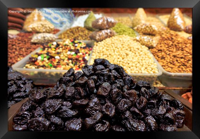 Hill of prunes on the background of various nuts in a blur. Framed Print by Sergii Petruk