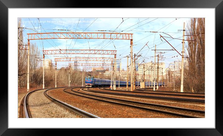 Passenger train cars of the train ride on the railway tracks in the background of the cityscape Framed Mounted Print by Sergii Petruk