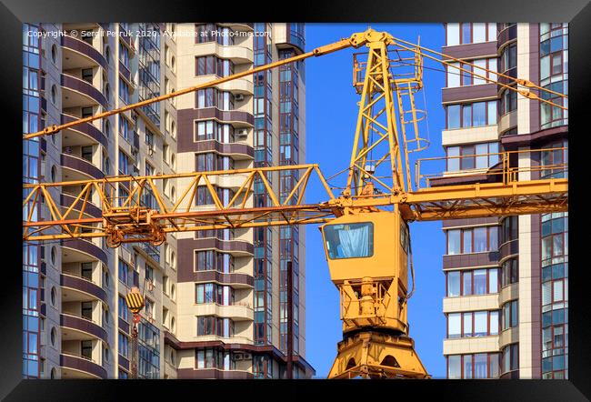 Crane between the facades and near the modern residential building under construction. Framed Print by Sergii Petruk