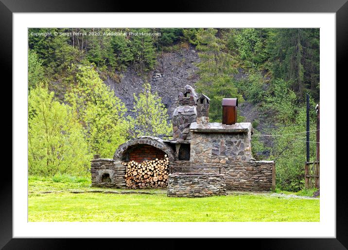 Old stone stove with firewood and smokehouse in the mountains of the Carpathians. Framed Mounted Print by Sergii Petruk