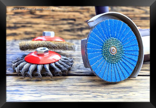 Angle grinder with grinding disc brushes lies on the background of a wooden table. Framed Print by Sergii Petruk
