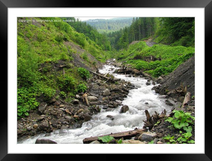 Mountain river runs from the peaks of the Carpathian Mountains among the boulders and old logs between the hills. Framed Mounted Print by Sergii Petruk