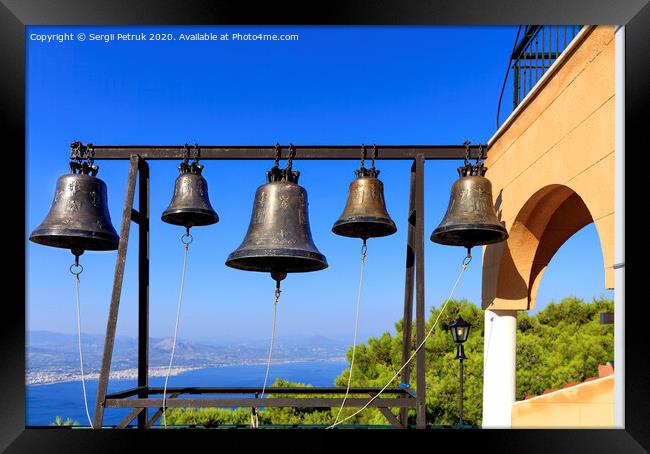Closeup of bells against a blue sky, mediterranean pine and sea coast in blur, Greece, August 2019. Framed Print by Sergii Petruk