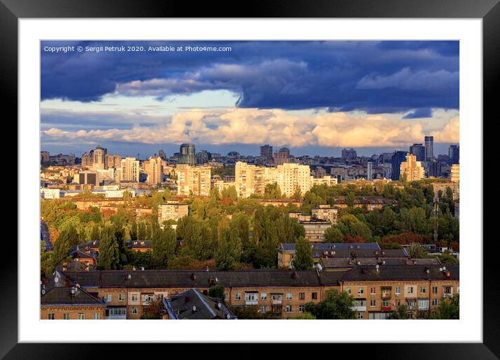The beautiful light of the setting sun falls on the houses in the city landscape. Framed Mounted Print by Sergii Petruk