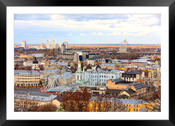 The landscape of the autumn city of Kyiv overlooking the old district of Podil with a Ferris wheel and a bell tower with a gilded dome, the Dnipro River and many bridges. Framed Mounted Print by Sergii Petruk