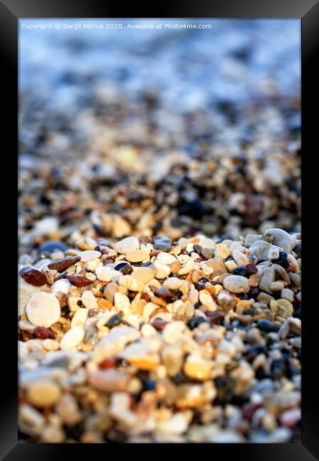 Beach pebbles backlit by a bright sunbeam. Framed Print by Sergii Petruk
