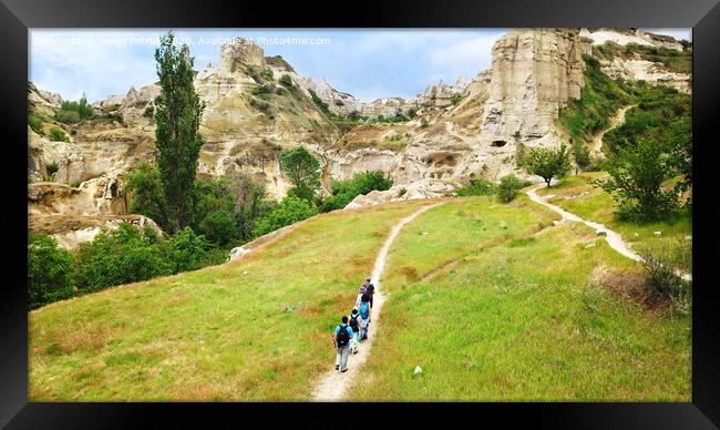 A group of tourists follow each other along a dirt path in Cappadocia, in central Turkey, a top view. Framed Print by Sergii Petruk