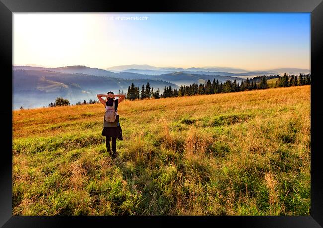 Young woman inhales the aroma of wild herbs and flowers at sunrise on a hilltop in the Carpathians. Framed Print by Sergii Petruk