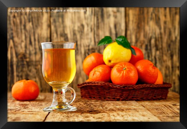 Citrus tea in a glass cup on a background of mandarin and lemon fruits in blur. Framed Print by Sergii Petruk