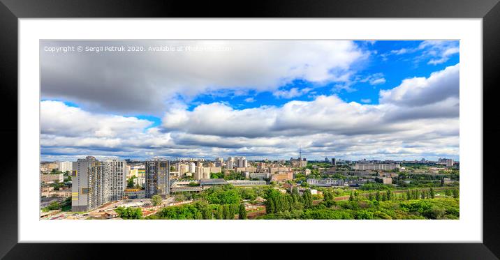 Panorama of cityscape with big low clouds and bright sunlight. Framed Mounted Print by Sergii Petruk