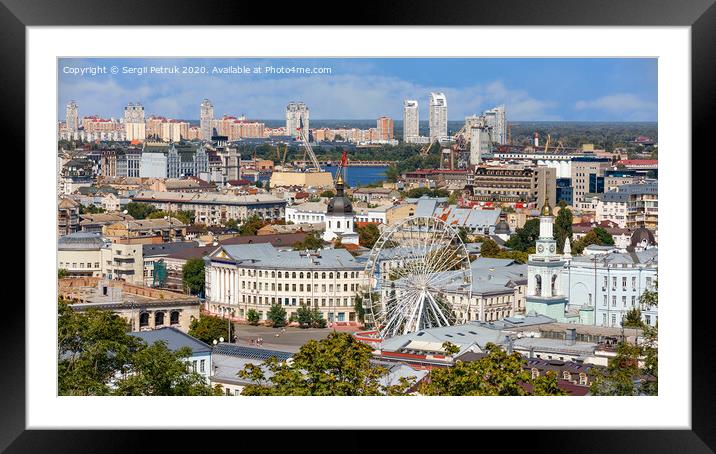The landscape of the summer city of Kyiv overlooking the old district of Podil with a Ferris wheel and a bell tower with a gilded dome, the Dnipro River and many city buildings. Framed Mounted Print by Sergii Petruk