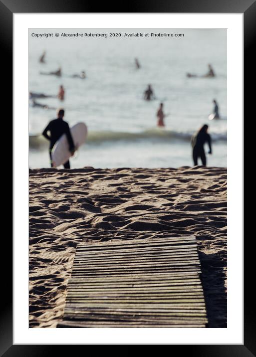 Wooden boards on beach leading to surfers on water Framed Mounted Print by Alexandre Rotenberg