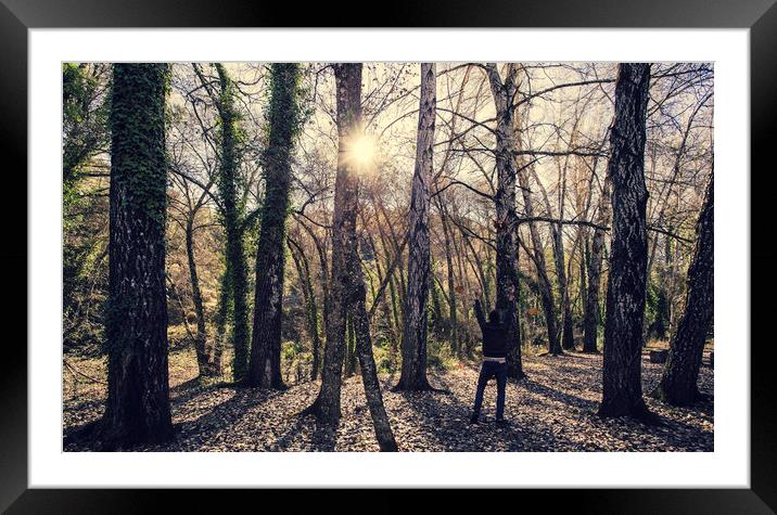 Young boy playing with leaves in the forest Framed Mounted Print by Juan Ramón Ramos Rivero