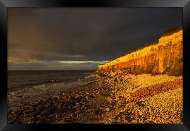 Hunstanton Cliffs at sunset with dark stormy sky Framed Print by Andrew Michael