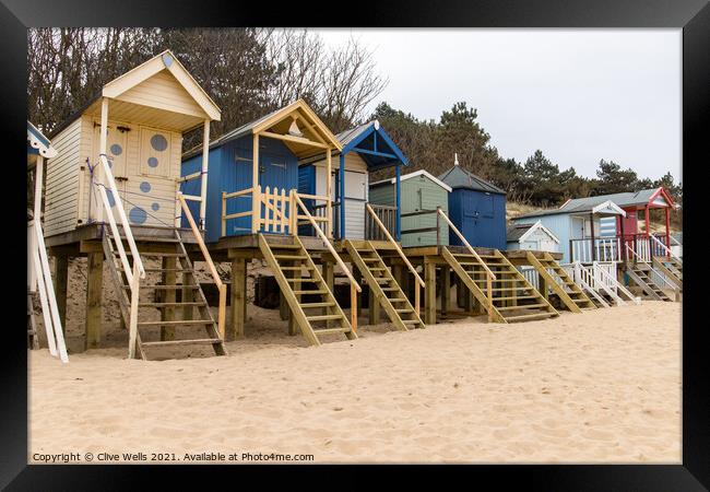 Beach huts above the sand Framed Print by Clive Wells