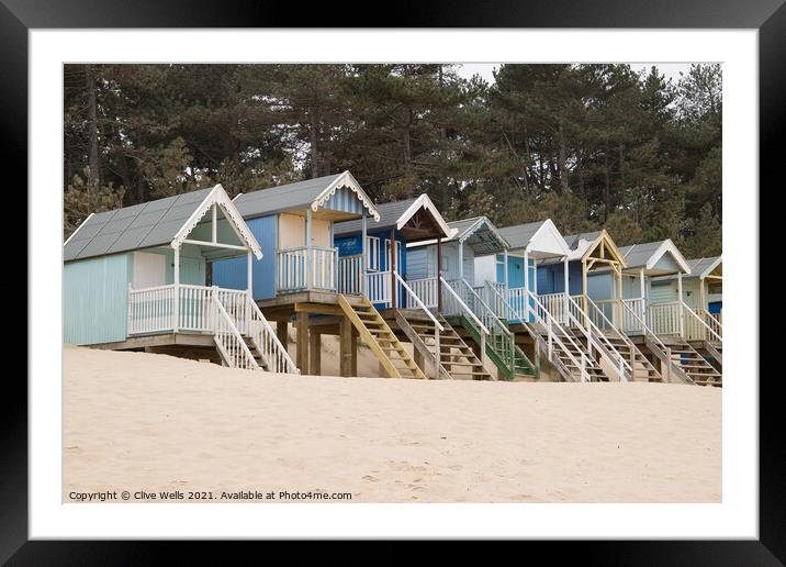 Row of beach huts against the pine trees Framed Mounted Print by Clive Wells