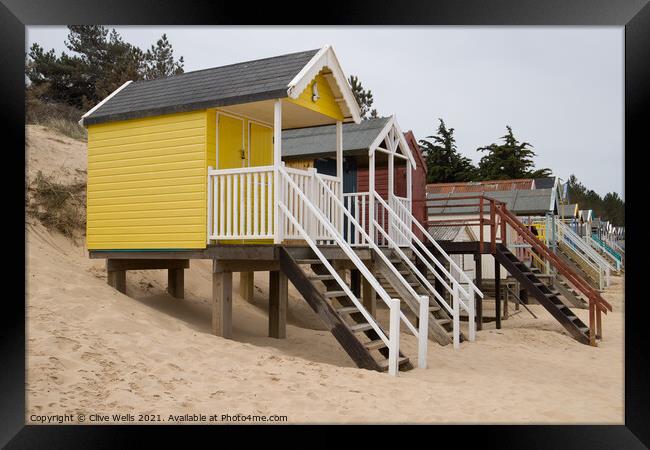 Row of beach huts Framed Print by Clive Wells