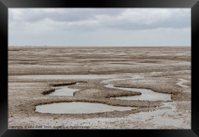 Mud flats seen at Snettisham beach in Norfolk Framed Print by Clive Wells