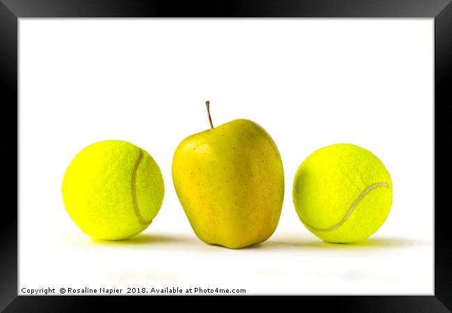 Yellow apple between two tennis balls Framed Print by Rosaline Napier