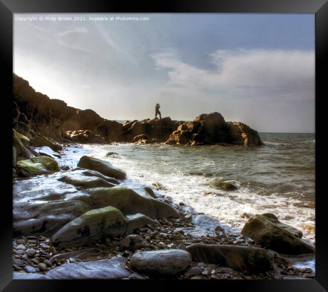 Man on the rocky shores of Tresaith, South Wales Framed Print by Philip Brown