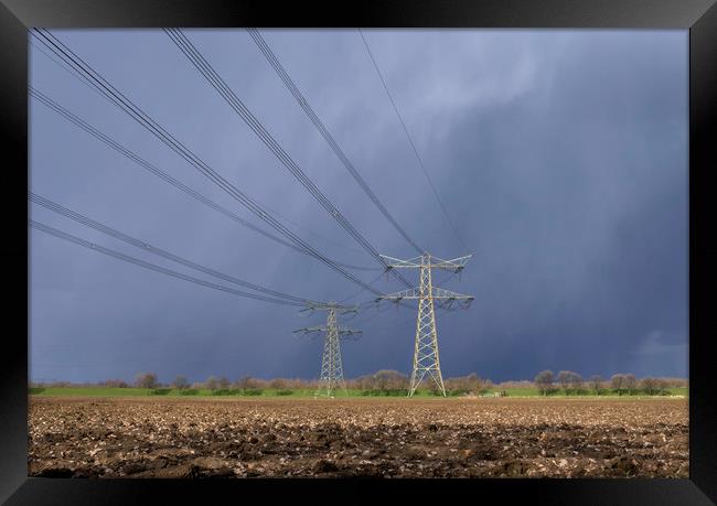 Power pylon in bad weather Framed Print by John Stuij