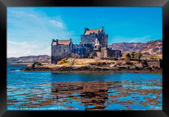 Eilean Donan A castle surrounded by a body of wate Framed Print by Holly Burgess
