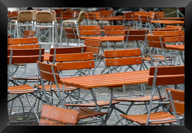 Unoccupied chairs and tables in a garden restaurant  Framed Print by Frank Heinz