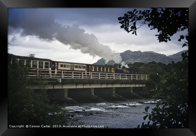 Train flying over a bridge Framed Print by Connor Carter