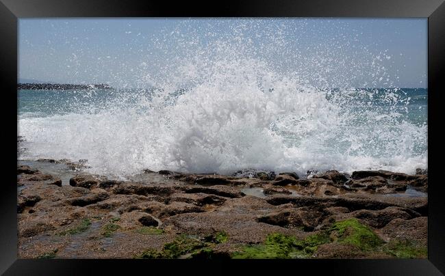 Waves arriving at the coast and splashing on the rocky shore Framed Print by Lensw0rld 