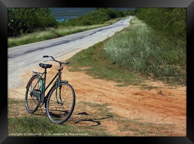 Retro bike next to an empty road in Cuba Framed Print by Lensw0rld 
