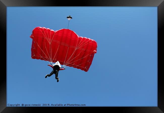 parachutist with red parachute on blue sky Framed Print by goce risteski