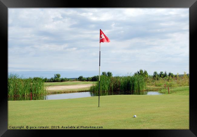 golf course with red flag and ball Framed Print by goce risteski