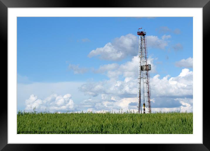 oil drilling rig on green wheat field Framed Mounted Print by goce risteski