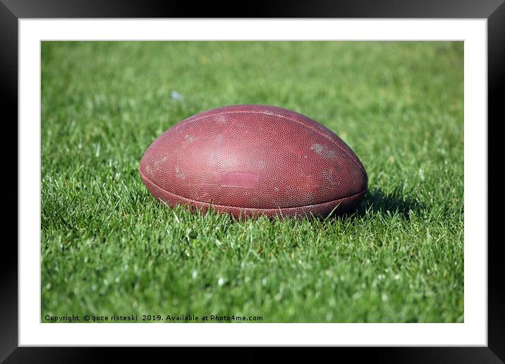 old American football ball on green grass Framed Mounted Print by goce risteski