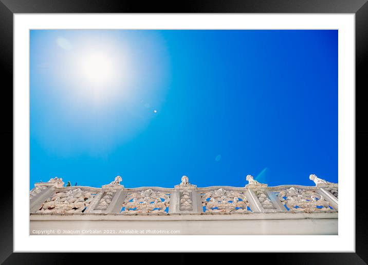 Old style stone balustrade, bottom view with blue sky background Framed Mounted Print by Joaquin Corbalan