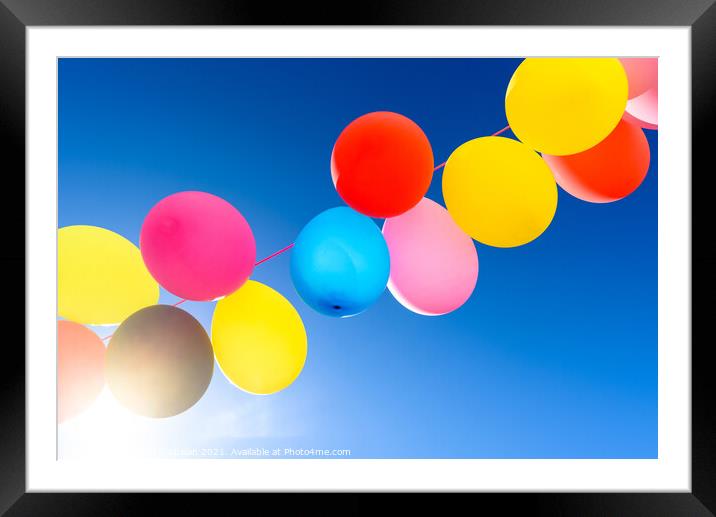 Pretty sunlit solid color balloons viewed from below with blue s Framed Mounted Print by Joaquin Corbalan