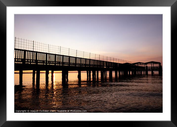 An old ramshackle pier with broken boards, during a beautiful su Framed Mounted Print by Joaquin Corbalan