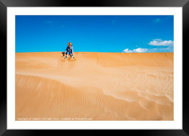 A child played on the sand dunes having fun with freedom, negati Framed Mounted Print by Joaquin Corbalan