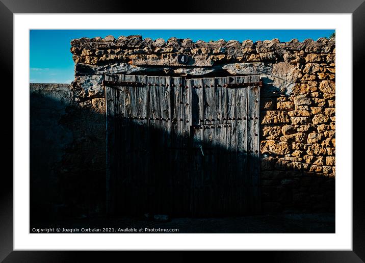 Old and decrepit wooden gate, half lit by the sun, in an unpopul Framed Mounted Print by Joaquin Corbalan