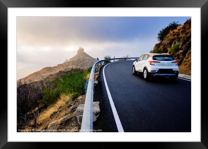 A family of tourists by car approaches the Roque Bentayga highwa Framed Mounted Print by Joaquin Corbalan
