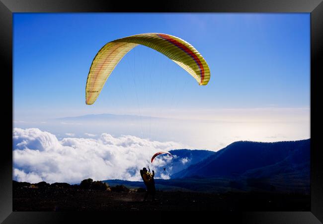 Skydiving experts and monitors prepare the sail of a paraglider  Framed Print by Joaquin Corbalan