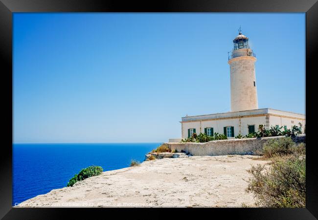 Formentera's lighthouse next to the sea cliff illuminates the co Framed Print by Joaquin Corbalan